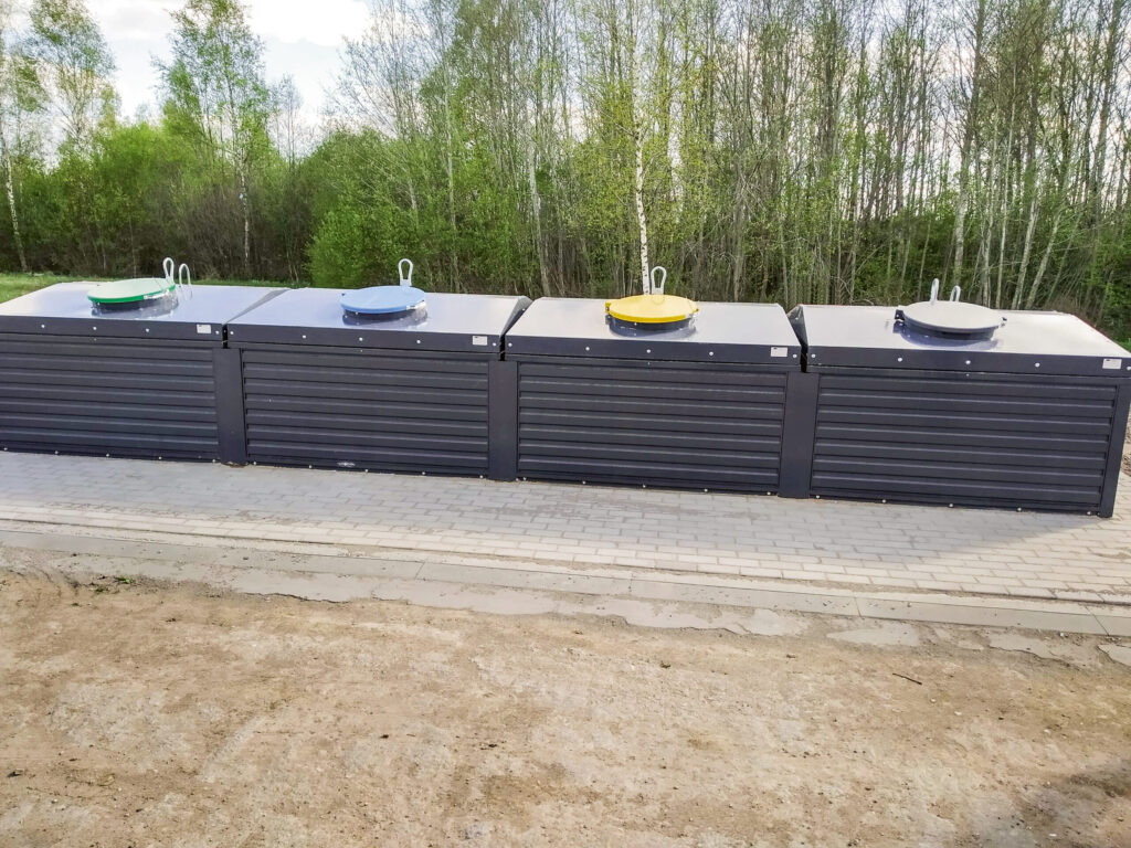 Vier Semi-Sub-Container stehen nebeneinander in einer ländlichen Gegend